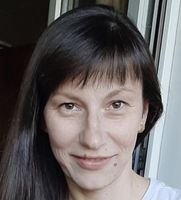 Porträt einer lächelnden Frau mit kurzem Haar