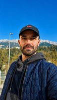 Porträt eines Mannes mit Outdoor-Kleidung vor Bergkulisse