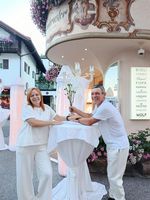 Paar übergibt Brautstrauß vor Hotel- oder Restaurantgebäude