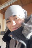 Person mit grauer Mütze und Winterjacke im Freien