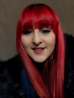Porträt einer Person mit roten Haaren und dunklem Pelzaccessoire